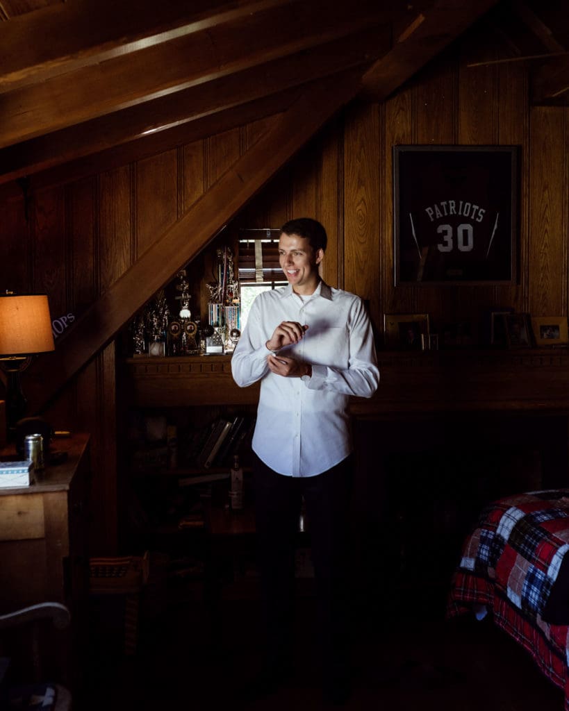 Photo Ops: Groom Thomas getting ready in the bedroom of childhood home-turned-wedding-venue.